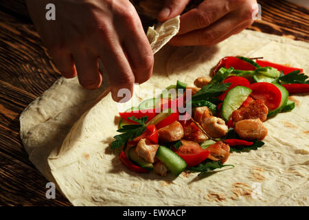 Cooking traditional shawarma wrap with chicken and vegetables Stock Photo