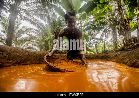 A woman preparing palm oil on a farm in Sierra Leone.