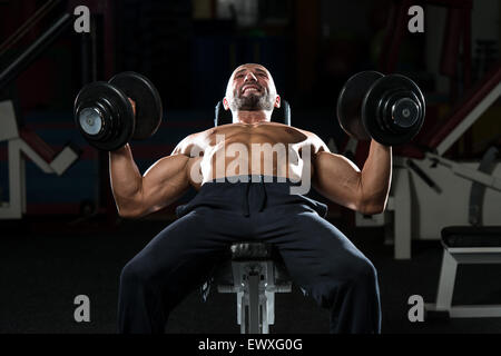 Mature Men Doing Dumbbell Incline Bench Press Workout In Gym Stock Photo