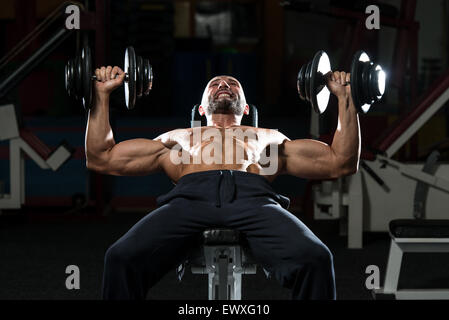 Mature Men Doing Dumbbell Incline Bench Press Workout In Gym Stock Photo