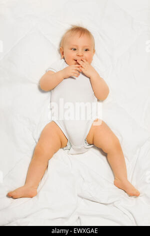 Chubby small baby with fingers near his mouth Stock Photo
