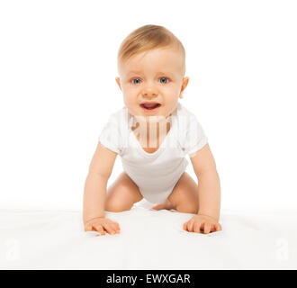 Sad looking baby crawling and wearing white body Stock Photo