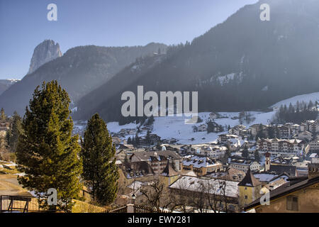 Panorama of Ortisei, Italian village in Dolomites Alps in Italy: valley of homes and buildings with snow-capped peaks and conifers in the background Stock Photo