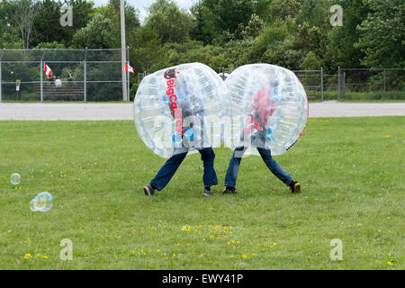 Two teenage boys bump into each other with their bumper balls at the Cannington Canada Day festivities in Ontario canada Stock Photo