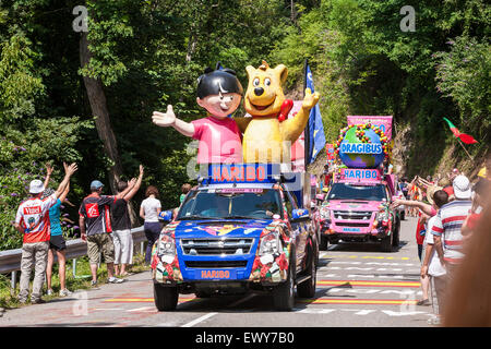 Prior to the cyclists arriving on each stage is the advertising /publicity caravans, which hand/throw out gifts to the crowds. Yellow jersey bank sponser. Here up the steep mountain to Plateau de Beille, 1,780 metres. This climb is classified as a HC climb, the steepest category, and is 15.8kms long, and climbs 1,255m over this distance.Tour de France, world's most famous cycle race. Pyrenees, France. July 2011. Stock Photo