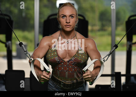 man and woman flexing muscles on gym machine Stock Photo - Alamy