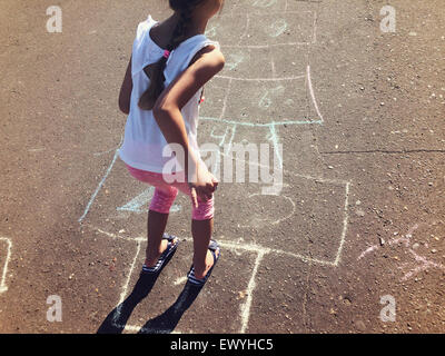 Girl Playing Hopscotch Stock Photo