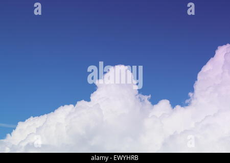 White cumulus clouds with a blue background sky. moving over the mountain tops Stock Photo