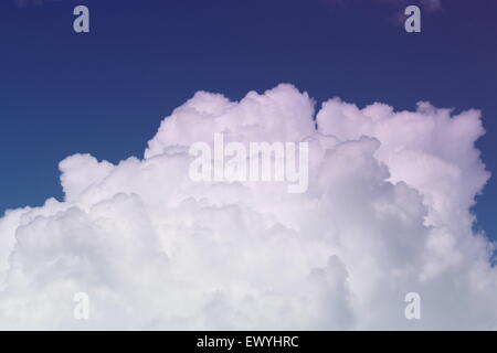 White cumulus clouds with a blue background sky. moving over the mountain tops Stock Photo