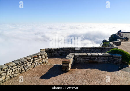 Stone wall at the edge of Table Mountain, Cape Town, looking over a layer of white clouds Stock Photo