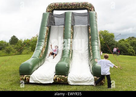 Young boy sliding down a bouncy castle and having fun at the Canada Day festivities in Cannington, Ontario Stock Photo