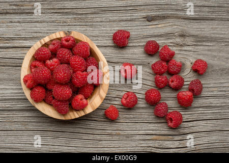 Raspberries in olive wood bowl on old wooden background Stock Photo