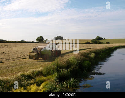 Grass being made into bales for silage next to the Bridgwater and Taunton Canal, Somerset, UK Stock Photo