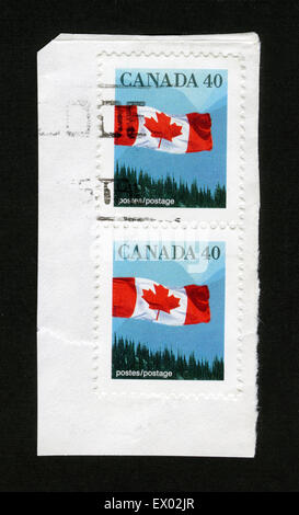 CANADA - CIRCA 1990: Postage stamp printed in Canada, shows Flag and mountain landscape, circa 1990 Stock Photo