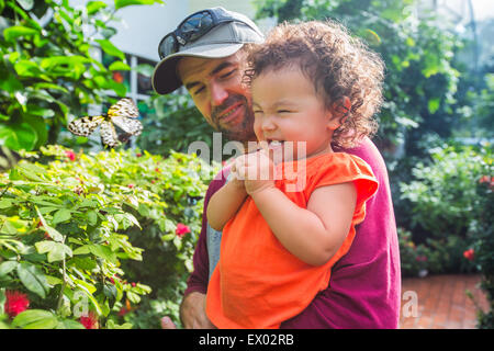 Father and daughter looking at butterfly Stock Photo