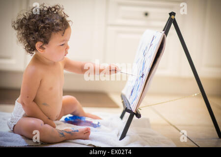 Little girl painting in kitchen Stock Photo
