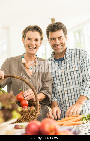 Portrait of couple preparing fresh vegetables in kitchen Stock Photo