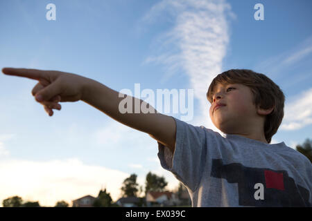 Low angle view of boy pointing finger in park Stock Photo