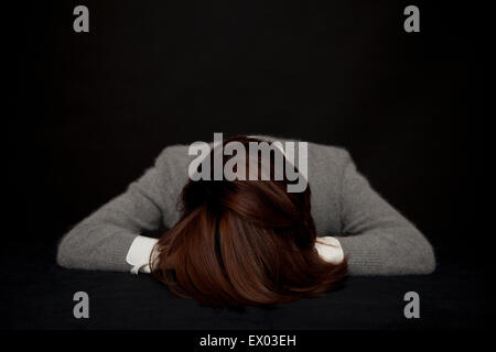 Portrait of woman resting head on table Stock Photo