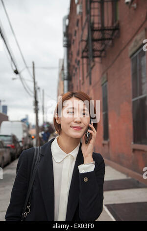 Businesswoman using smartphone on street Stock Photo