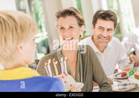 Boy handing birthday cake to grandmother in dining room Stock Photo - Alamy