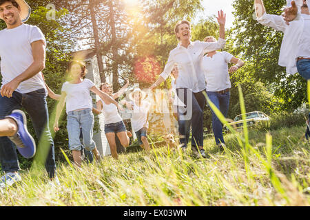 Group of people running through forest Stock Photo