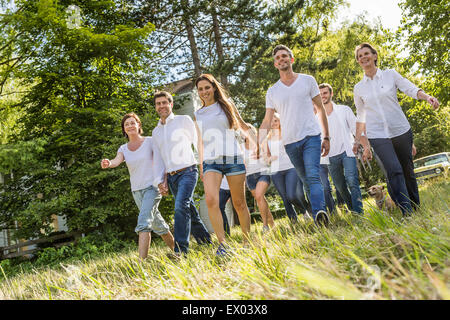 Group of people walking through forest Stock Photo