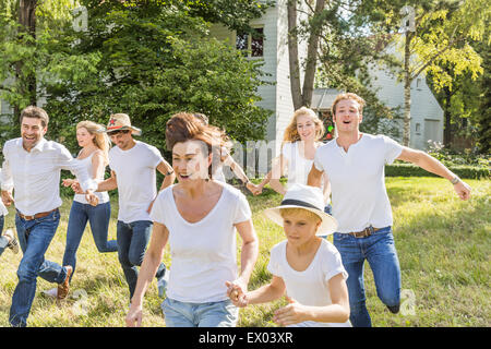 Group of people running through forest Stock Photo