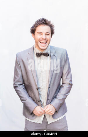 Portrait of young man wearing silver suit jacket and bow tie Stock Photo