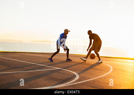 Two friends playing basketball, outdoors Stock Photo