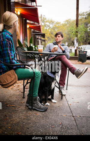 Couple with dog having coffee at sidewalk cafe, Savannah, Georgia, USA Stock Photo