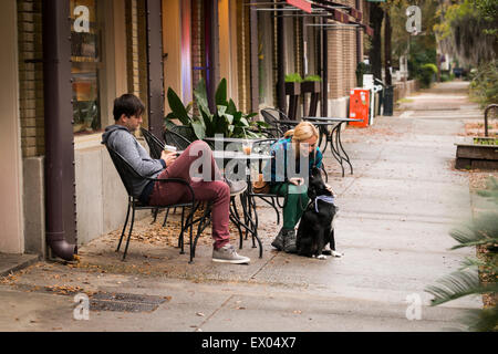 Couple with dog having coffee at sidewalk cafe, Savannah, Georgia, USA Stock Photo