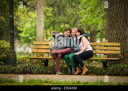 Friends taking selfie on park bench, Savannah, Georgia, USA Stock Photo