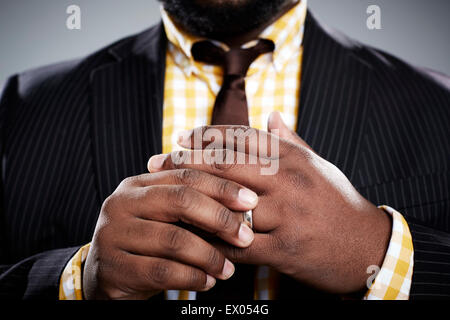 Close up studio portrait of mid adult businessman touching his wedding ring Stock Photo