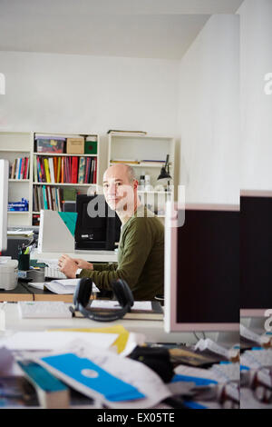 Mature man at desk in creative studio, portrait Stock Photo