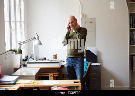 Mature man on the phone in creative studio Stock Photo