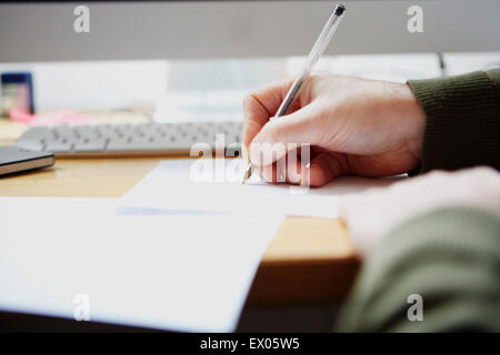 Man writing on paper with pen Stock Photo