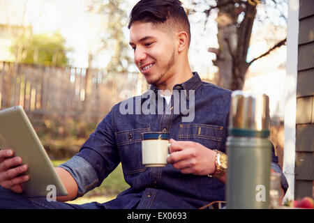 Young man using tablet with coffee Stock Photo
