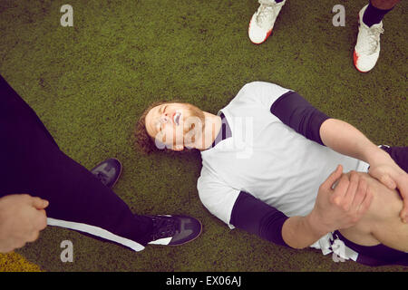 Injured male soccer player on soccer pitch Stock Photo