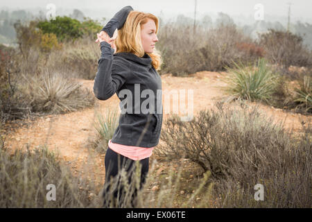 Young female runner doing warm up stretches Stock Photo