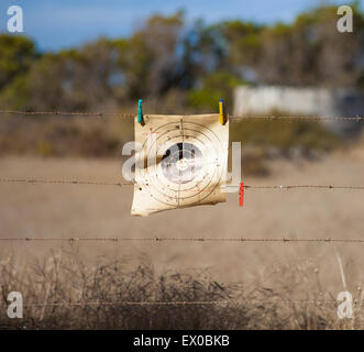 A paper target pegged to barbed wire Stock Photo