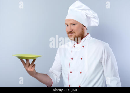 Head-cook holding plate and looking at camera Stock Photo