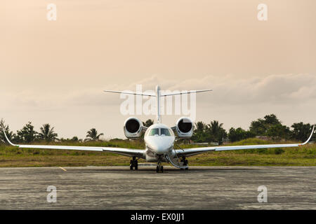 Private jet sits on the runway on a tropical island Stock Photo