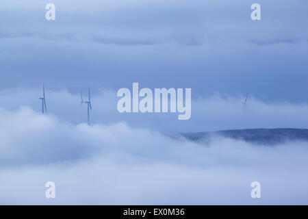 Wind Turbines poking through mist on the edge of Stiperden Moor in the southern Pennines, near Burnley, Lancashire, UK Stock Photo