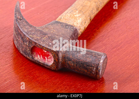 Small grungy old hammer on top of a wooden table Stock Photo