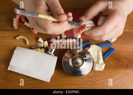 the dental technician is engaged in a modeling of artificial dentures Stock Photo