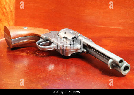 A replica of an old .44 six shooter revolver on a wooden cabinet Stock Photo