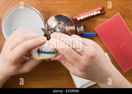 the dental technician is engaged in a modeling of artificial dentures Stock Photo