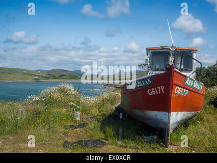 Red fishing boat close to shore with Twelve Bens mountains in distance Cleggan Connemara County Galway Eire Republic of Ireland Stock Photo
