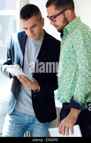 Portrait of two businessman using digital tablet in office. Stock Photo